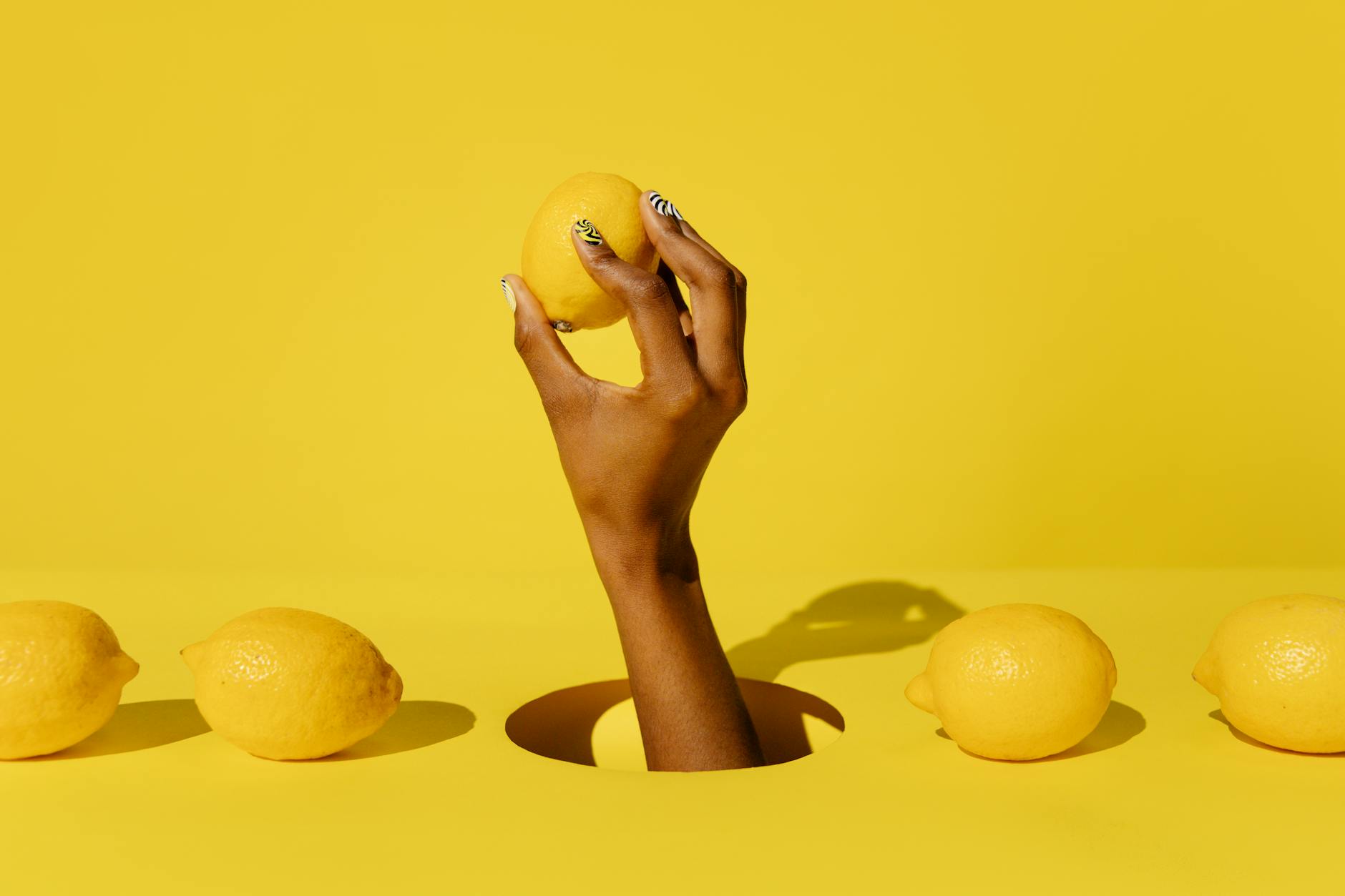 Yellow silicone vibrator surrounded by fresh fruit on a yellow background